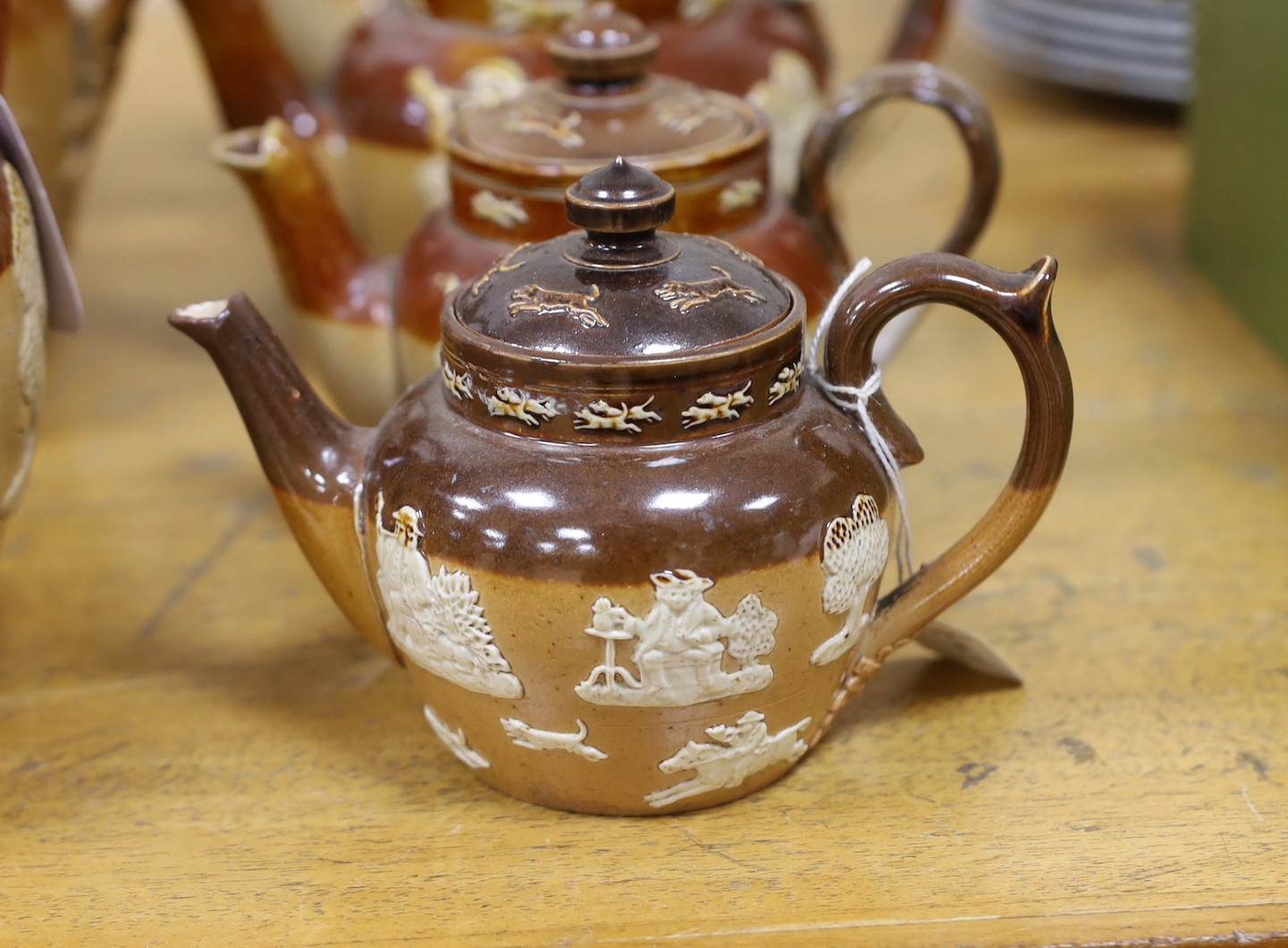 Eight various Royal Doulton Lambeth and other stoneware jugs and tea pots, one silver-mounted